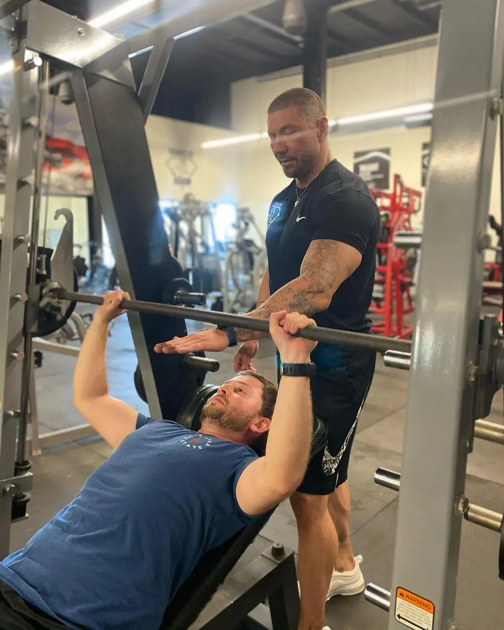A coach spotting a client on the bench press